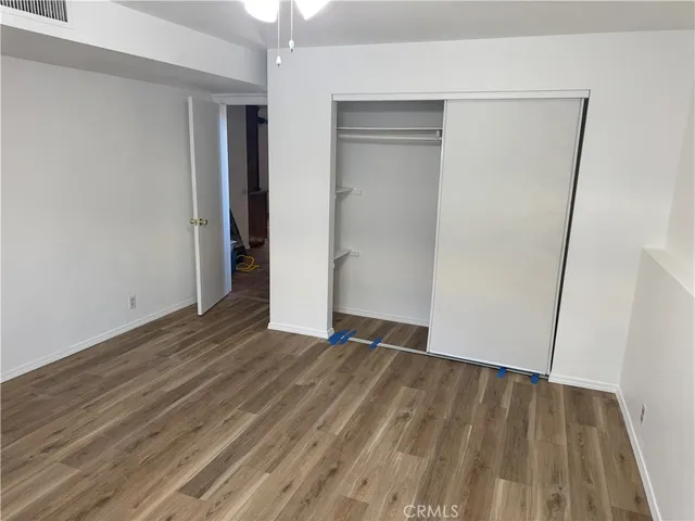 an empty room with wooden floor and closet