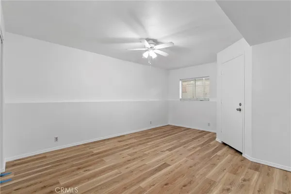 an empty room with a window and ceiling fan