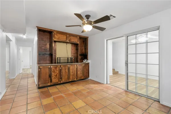 an empty room with wooden floor closet and windows