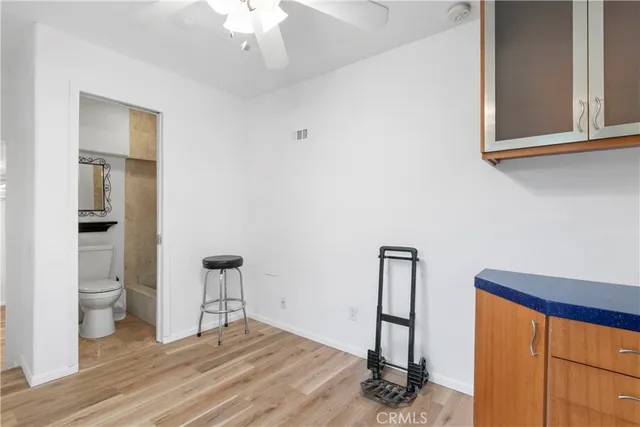 a view of a bedroom with wooden floor and windows