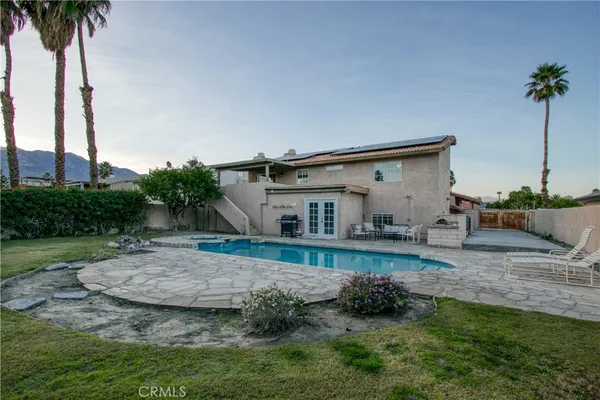 a view of a house with pool and sitting area
