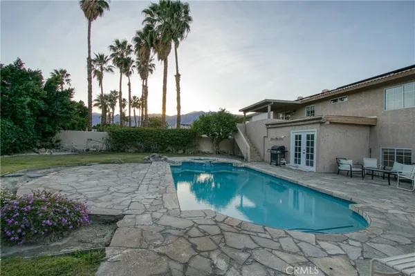 a swimming pool with outdoor seating and yard