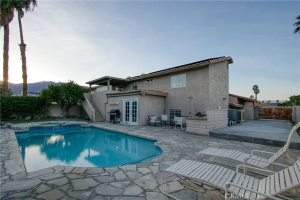 a backyard of a house with table and chairs