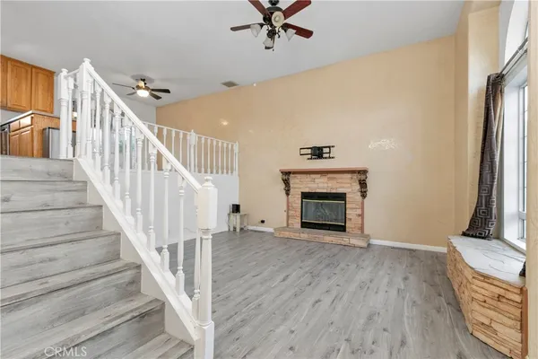 a view of a livingroom with wooden floor and a fireplace