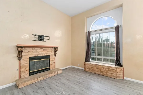 a living room with wooden floor and a fireplace