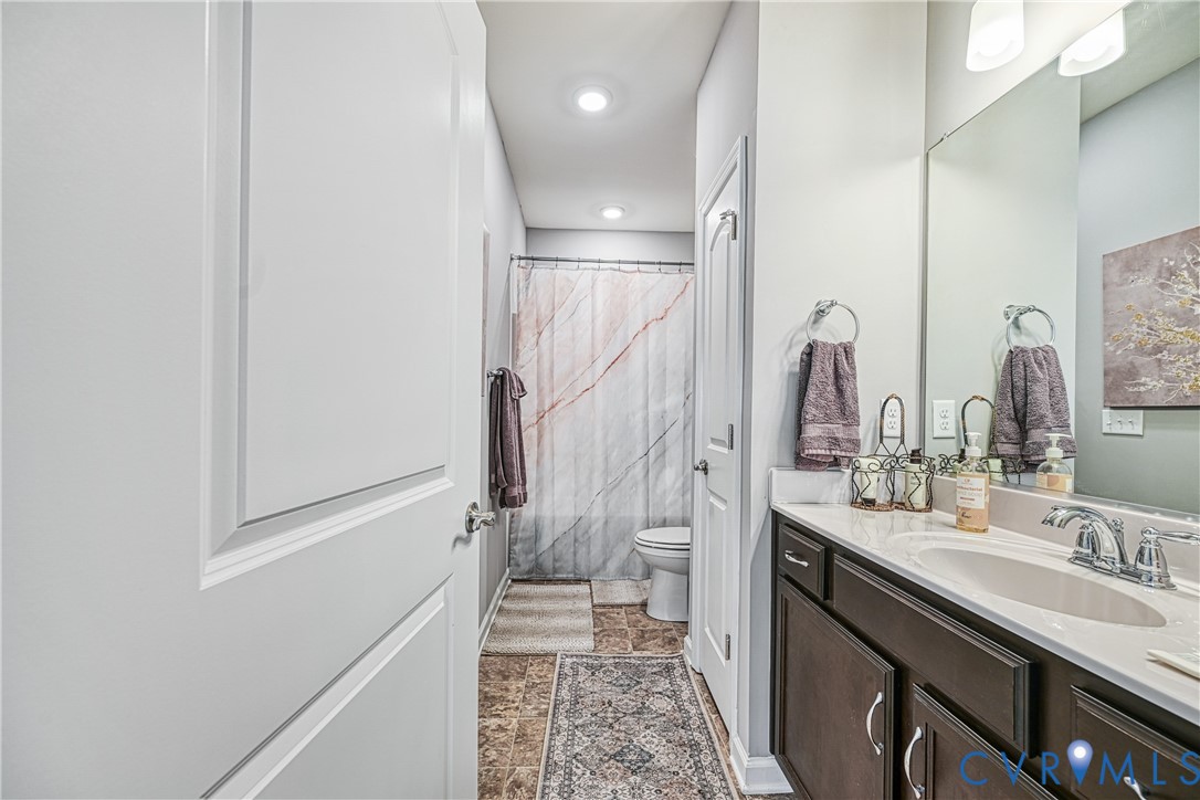 1009 Woodlet Meadow Lane Richmond, VA 23236 - Photo 32 of 44 a bathroom with a double vanity sink a toilet and a mirror