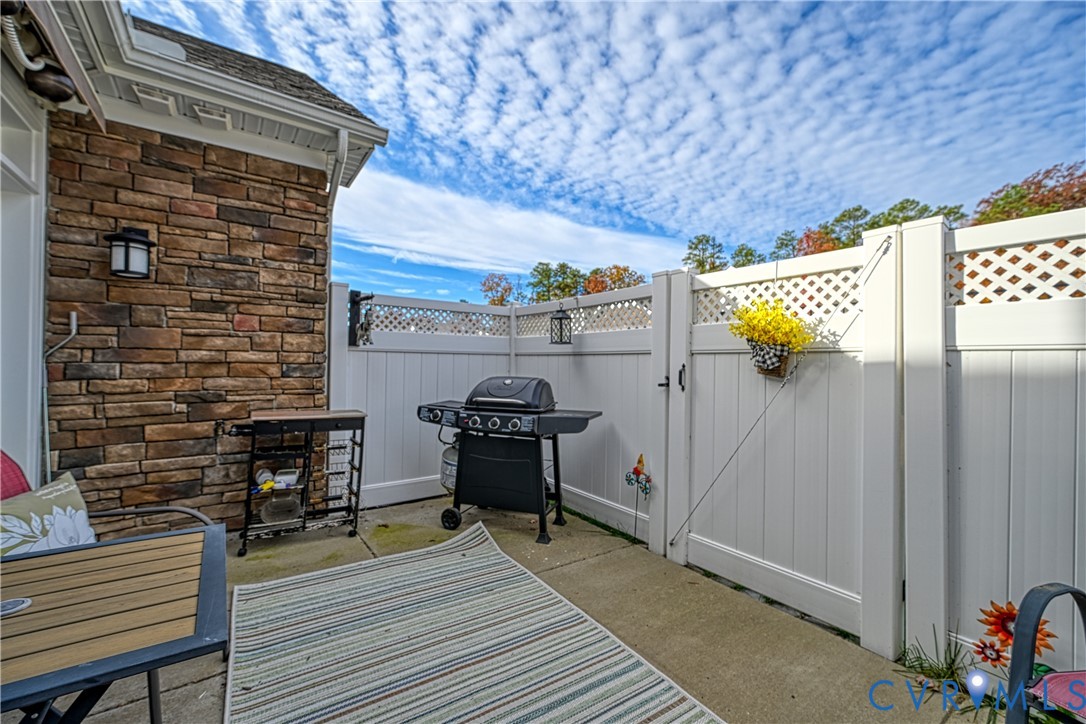 1009 Woodlet Meadow Lane Richmond, VA 23236 - Photo 36 of 44 a view of a patio with table and chairs with wooden floor and fence