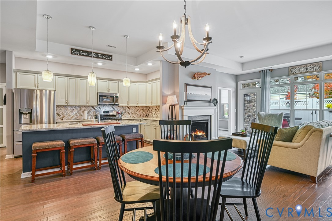 1009 Woodlet Meadow Lane Richmond, VA 23236 - Photo 9 of 44 a view of a dining room with furniture a chandelier and wooden floor