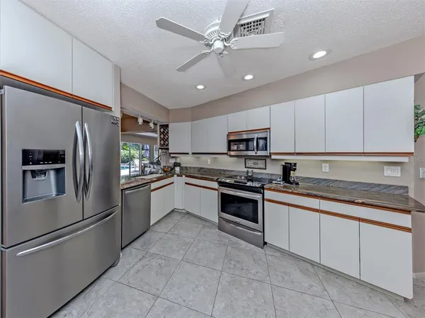 a kitchen with granite countertop stainless steel appliances and white cabinets