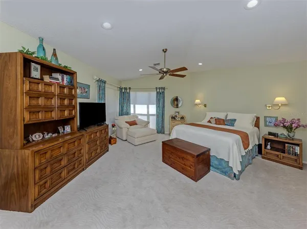 a spacious bedroom with a bed and a flat screen tv