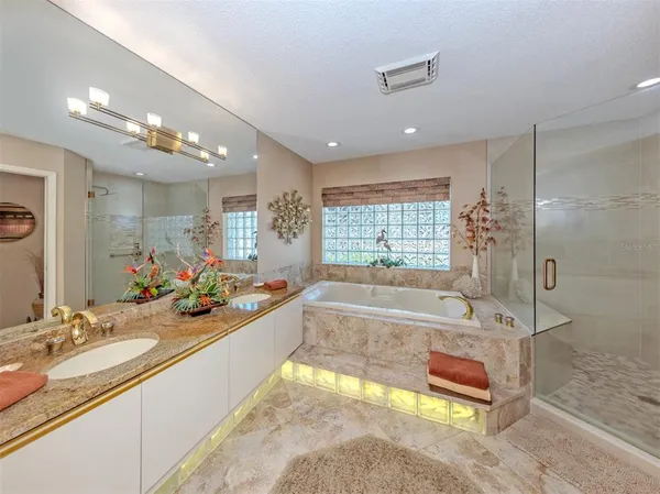 a spacious bathroom with a tub sink shower and mirror
