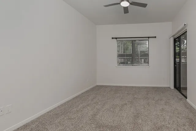 an empty room with a chandelier fan