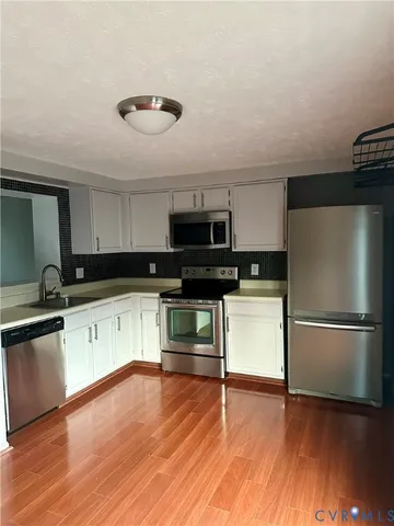a kitchen with granite countertop a refrigerator and a stove top oven