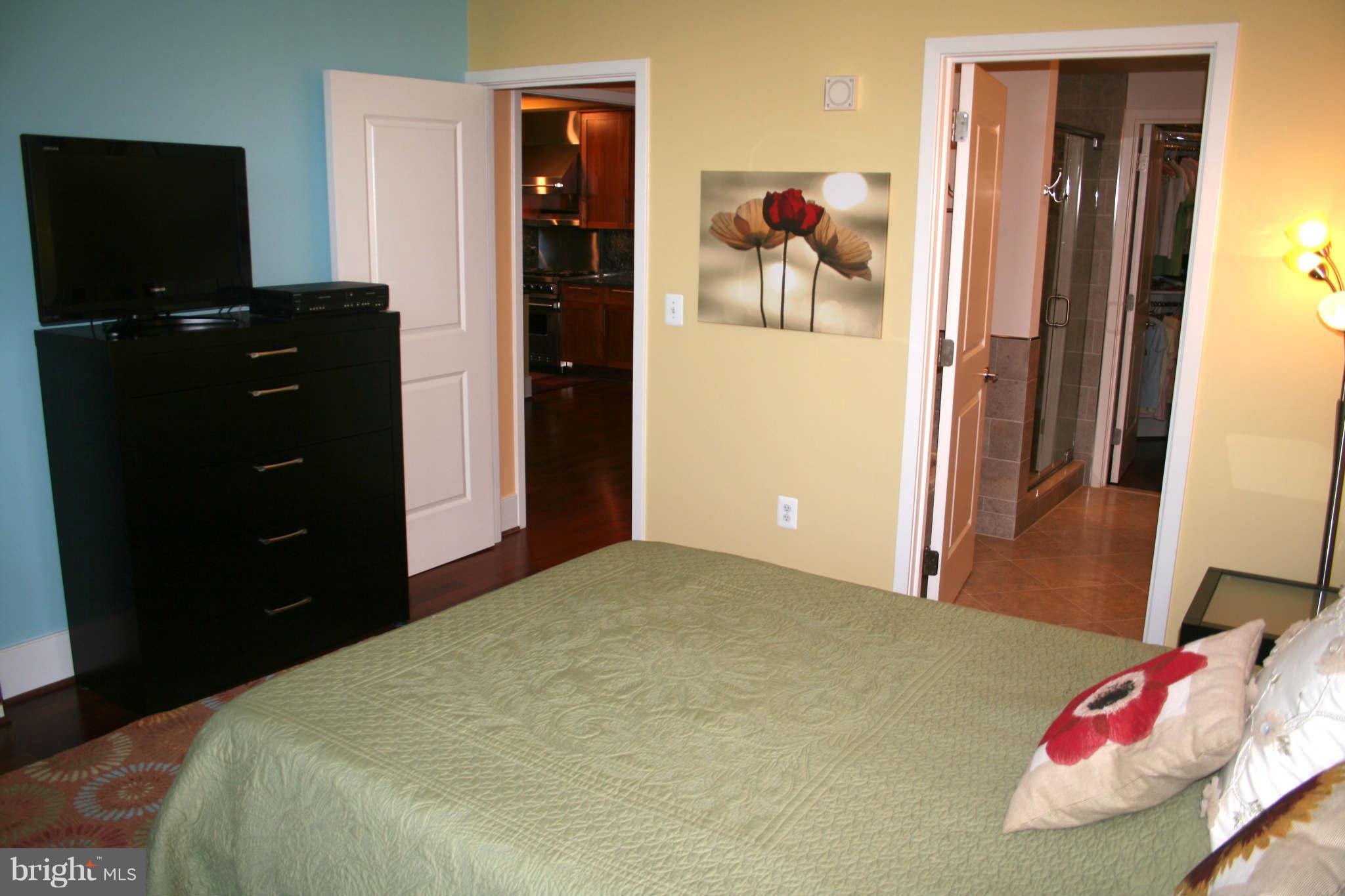 4301 Military Road Northwest, Unit 514 Washington, DC 20015 - Photo 13 of 29 a bedroom with a bed and a flat tv screen