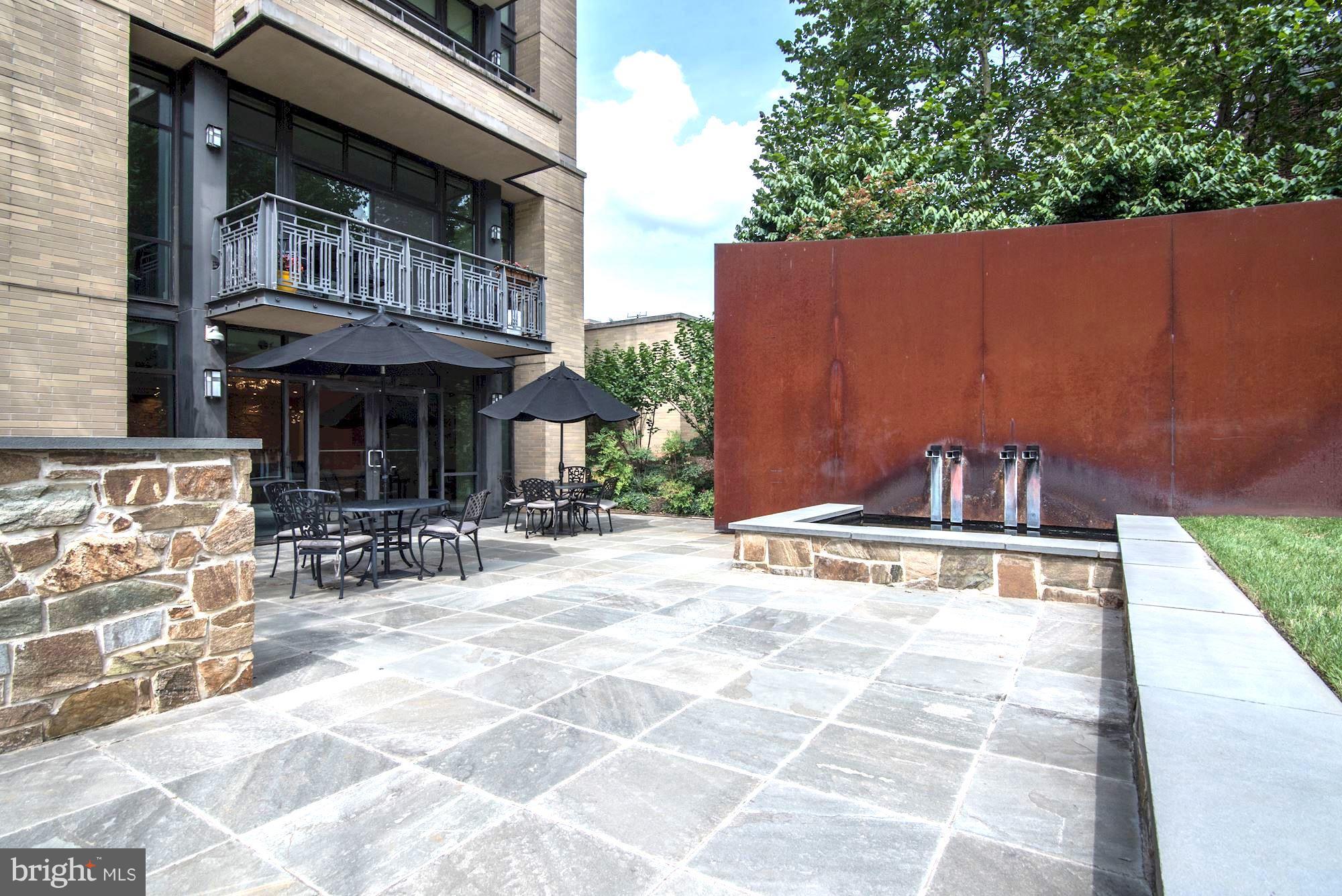 4301 Military Road Northwest, Unit 514 Washington, DC 20015 - Photo 19 of 29 a view of a patio with a table and chairs under an umbrella