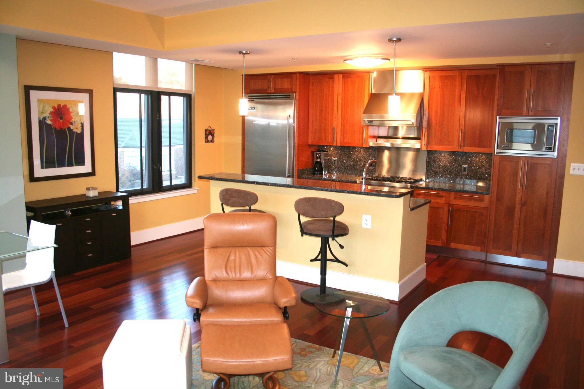 4301 Military Road Northwest, Unit 514 Washington, DC 20015 - Photo 10 of 29 a kitchen with stainless steel appliances granite countertop a stove a sink and a dining table