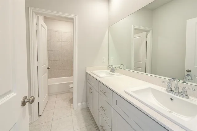 a bathroom with a double vanity sink a mirror and a bathtub