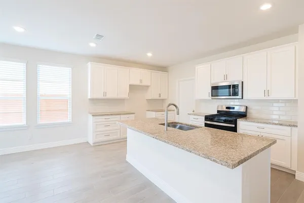 a kitchen with stainless steel appliances granite countertop a sink stove and cabinets