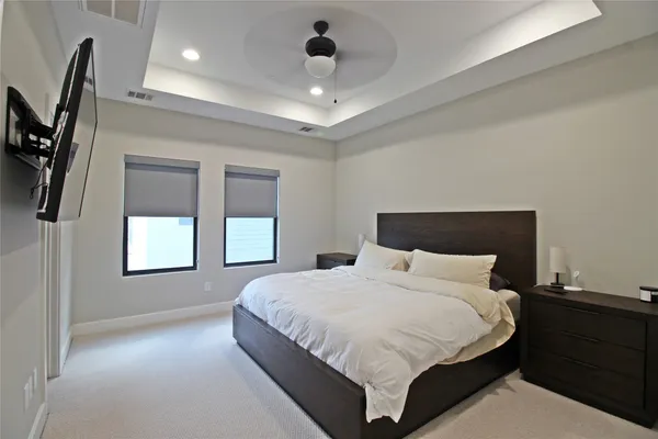 a bedroom with a large bed and a chandelier