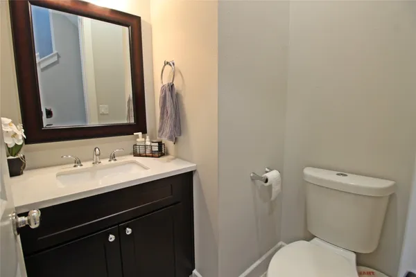 a bathroom with a granite countertop toilet sink and a mirror