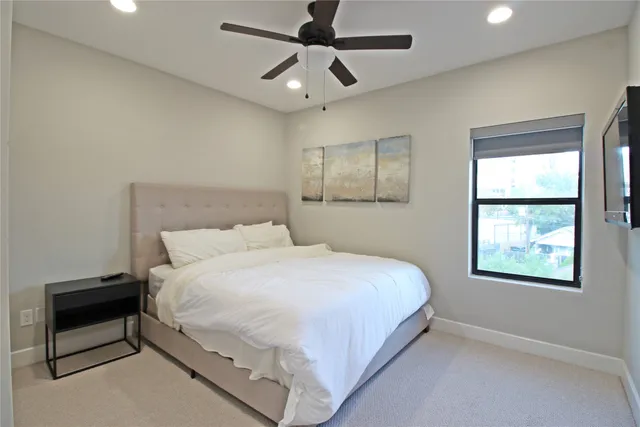 a large bed sitting in a bedroom next to a window