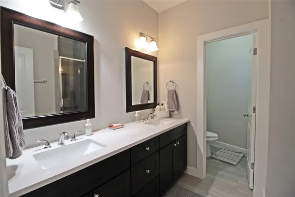 a bathroom with double vanity sinks and a mirror
