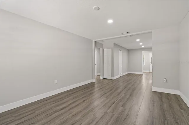 a view of an empty room with wooden floor