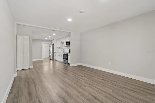 a view of empty room with wooden floor