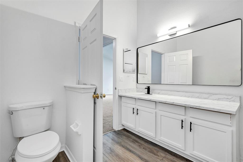 4254 Northern Dancer Way Orlando, FL 32826 - Photo 19 of 38 a bathroom with a toilet a sink and mirror