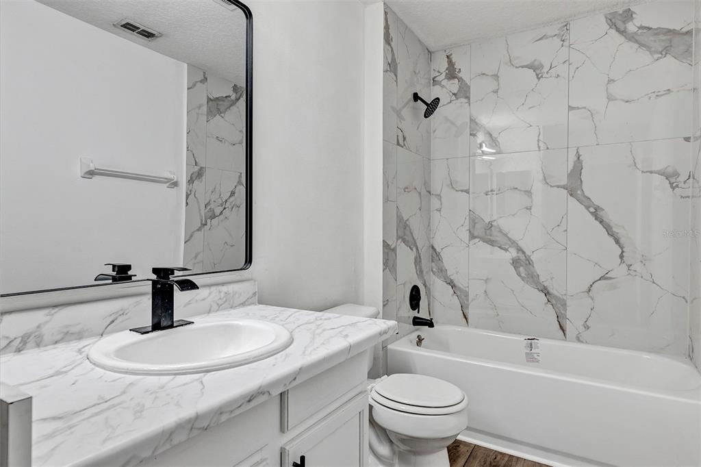 4254 Northern Dancer Way Orlando, FL 32826 - Photo 35 of 38 a bathroom with a granite countertop sink toilet and shower