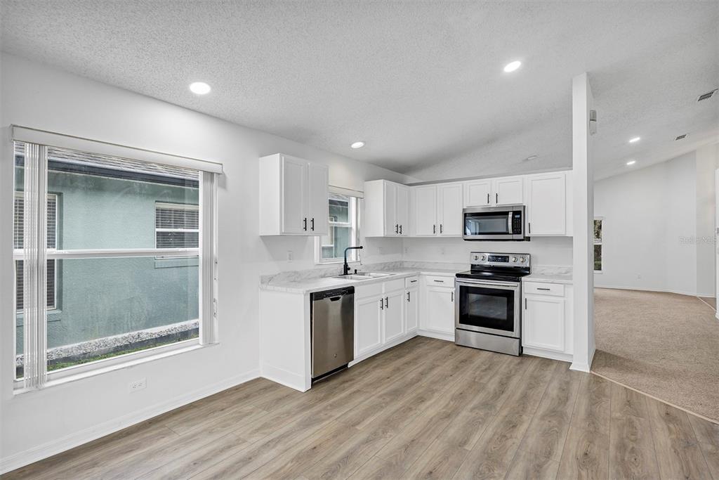 4254 Northern Dancer Way Orlando, FL 32826 - Photo 7 of 38 a kitchen with stainless steel appliances a stove top oven and a refrigerator