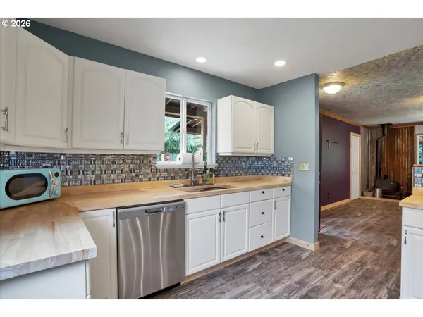 a kitchen with refrigerator cabinets and wooden floor