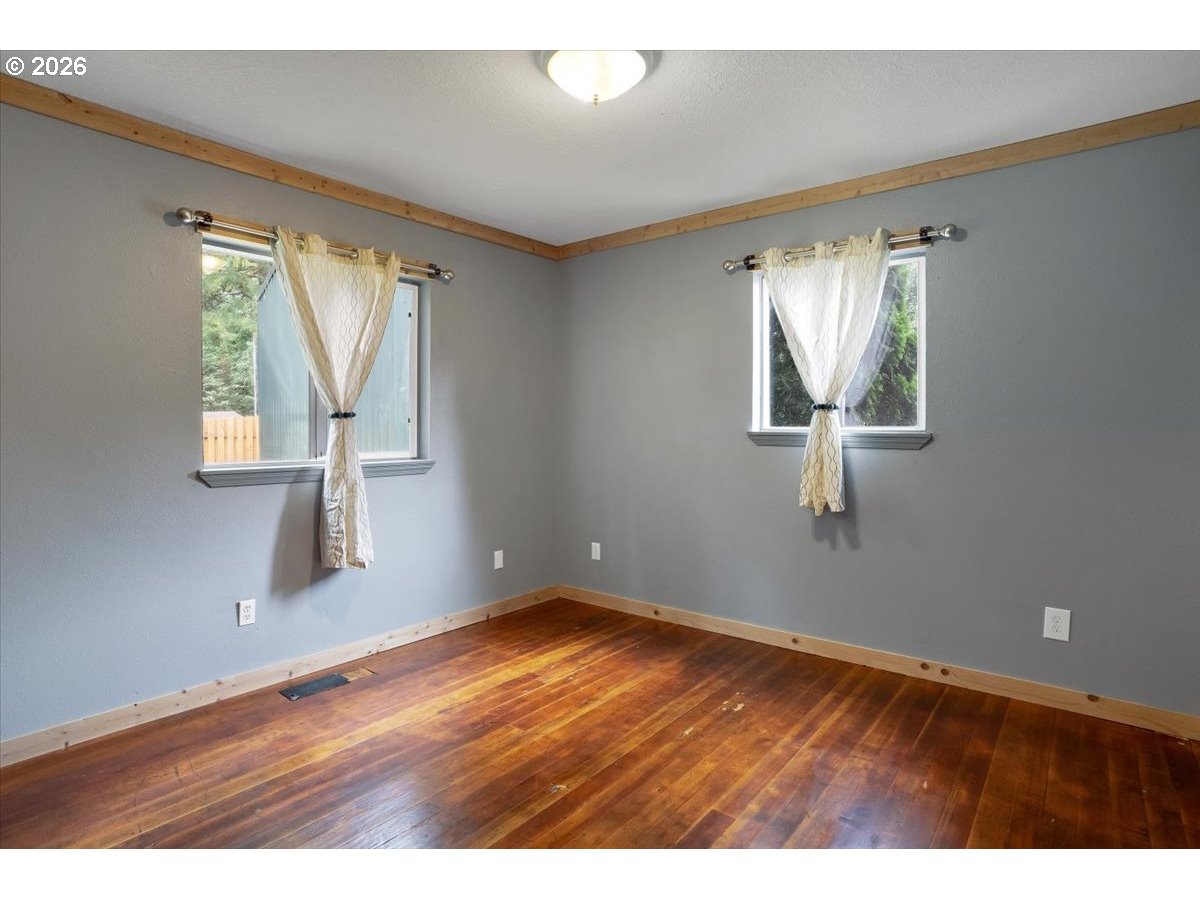 566 North Bear Creek Road Otis, OR 97368 - Photo 28 of 40 an empty room with wooden floor and windows