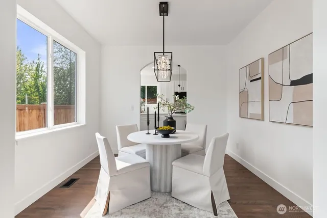 a dining room with furniture potted plants and wooden floor