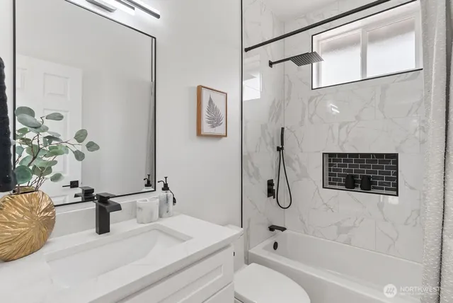 a bathroom with a granite countertop sink a toilet and shower