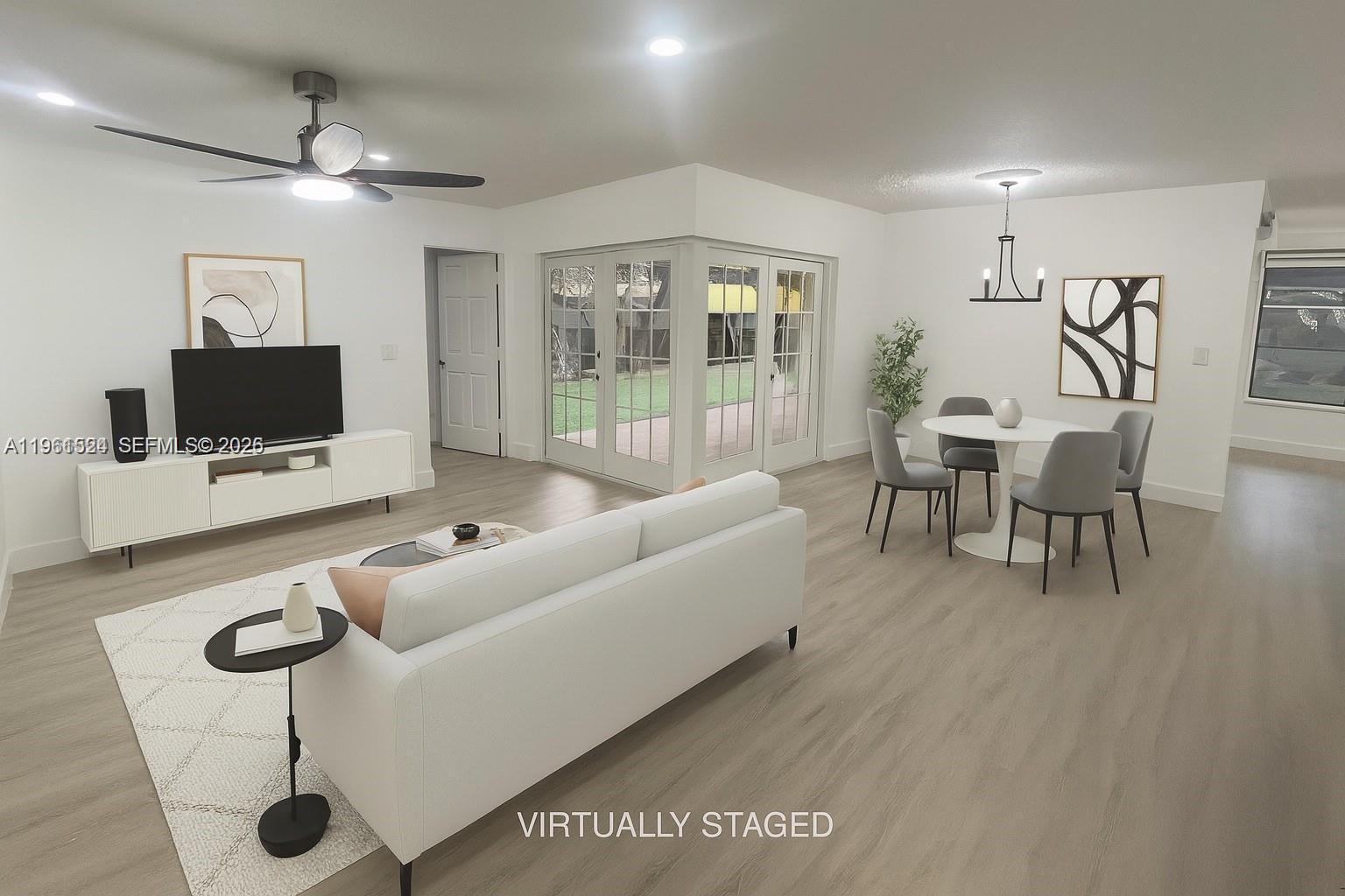 3250 Southwest 116th Place Miami, FL 33165 - Photo 3 of 15 a living room with furniture a flat screen tv and a floor to ceiling window