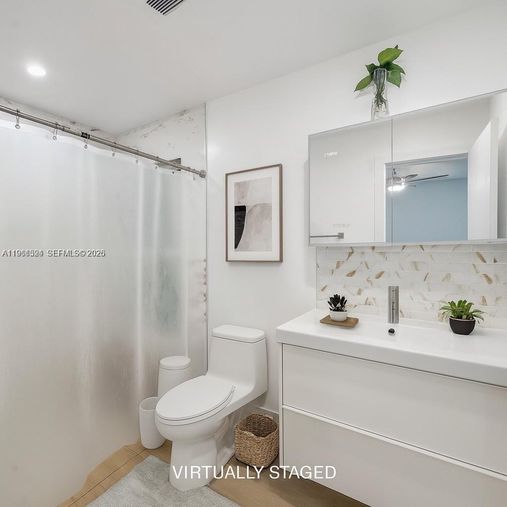 3250 Southwest 116th Place Miami, FL 33165 - Photo 7 of 15 a bathroom with a sink a toilet and a mirror