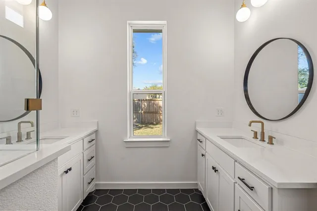 a bathroom with a double vanity sink mirror and