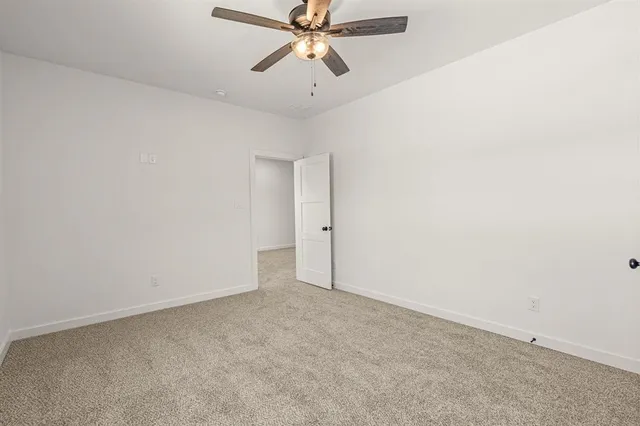 an empty room with chandelier fan