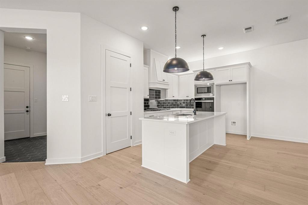 177 Hulen Circle Aledo, TX 76008 - Photo 5 of 21 a kitchen with kitchen island stainless steel appliances a stove a sink cabinets and a wooden floor
