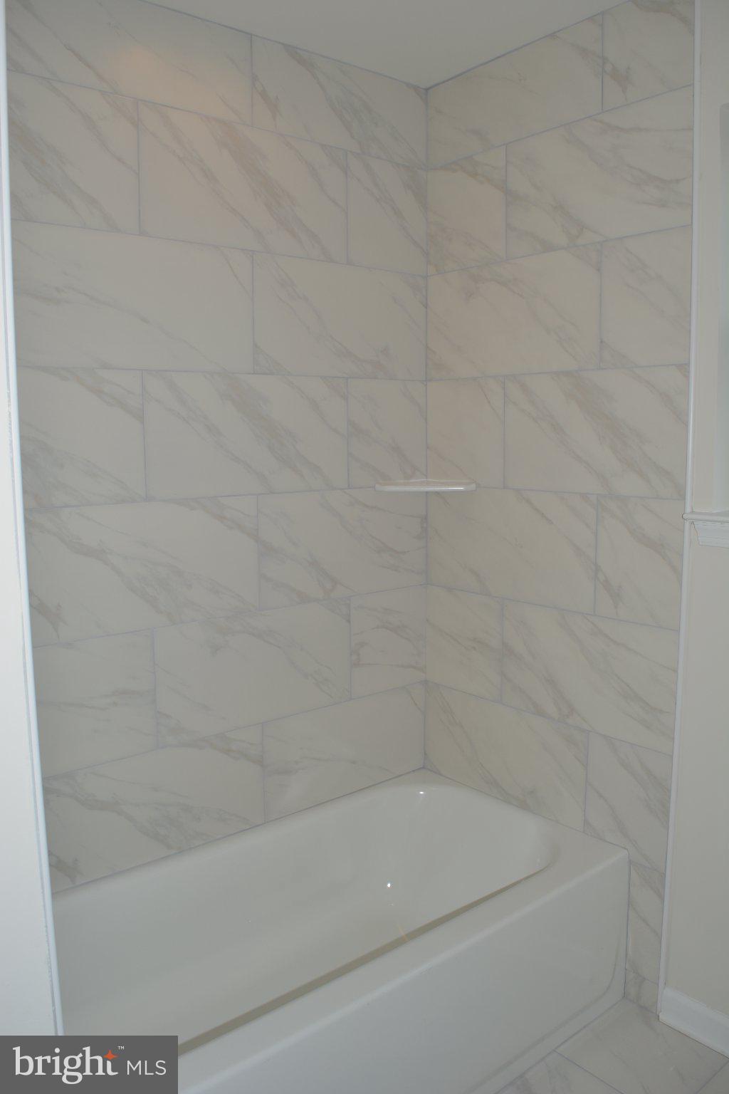 7631 Ridge Avenue, Unit 3 Philadelphia, PA 19128 - Photo 13 of 16 Elegant marble-tiled shower retreat.