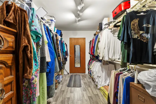 a view of walk in closet with clothes and shoes