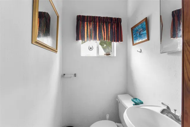 a bathroom with a toilet sink and mirror