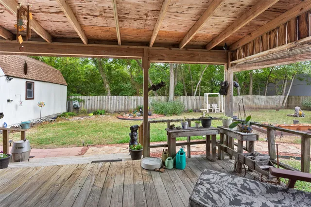 a view of a patio with table and chairs potted plants with wooden floor and fence