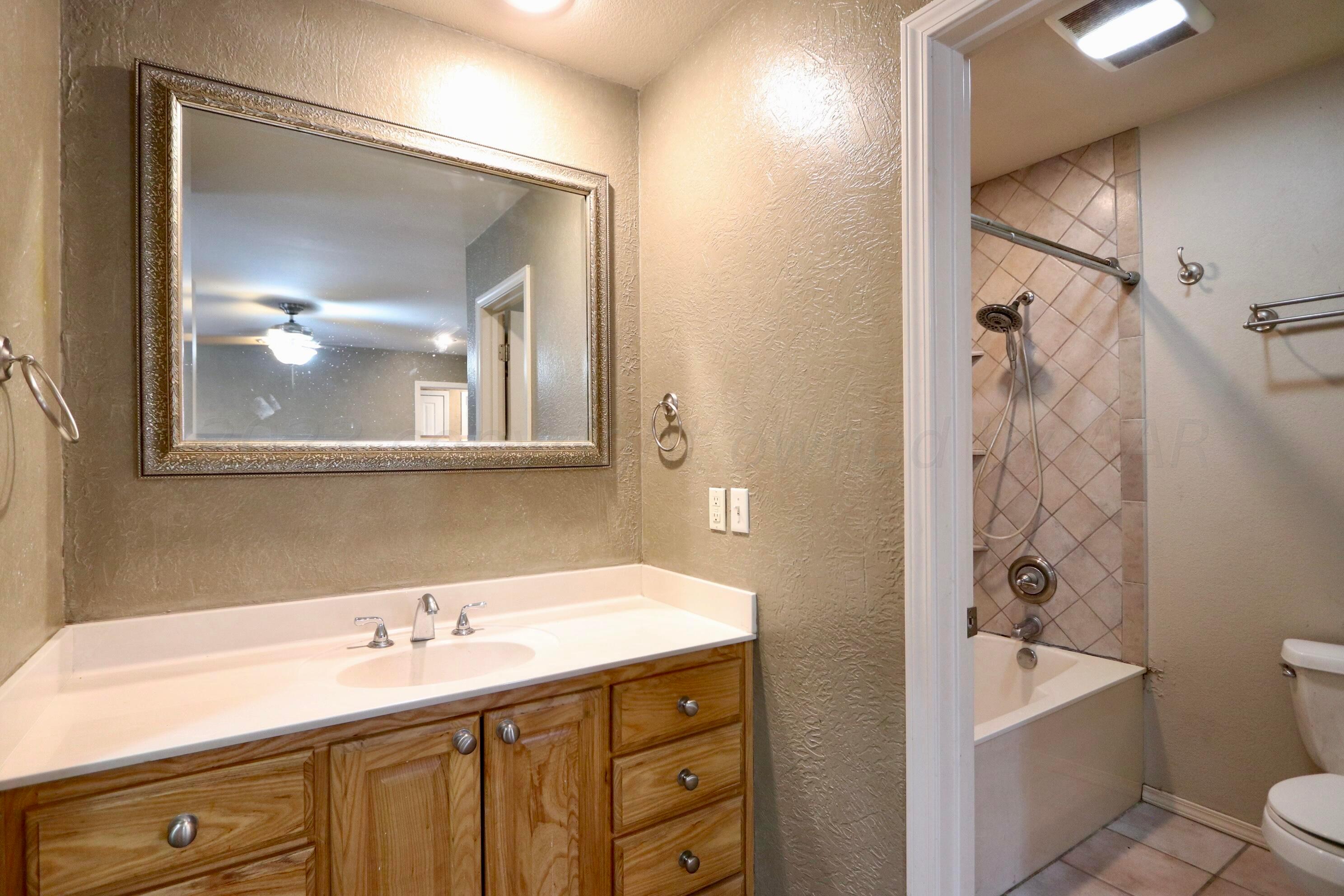 7916 Fenley Drive Amarillo, TX 79121 - Photo 15 of 23 a bathroom with a tub a sink and mirror