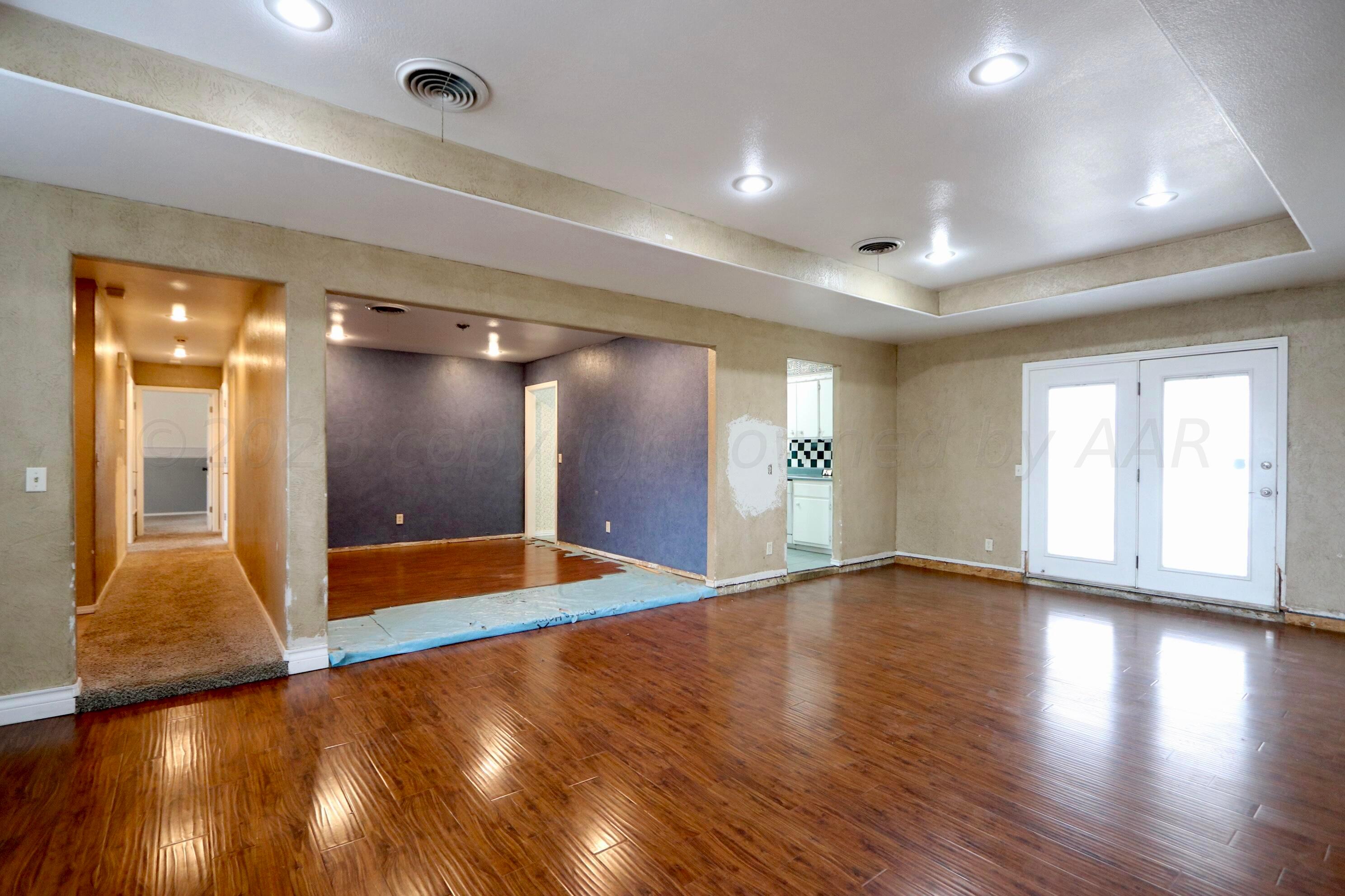 7916 Fenley Drive Amarillo, TX 79121 - Photo 6 of 23 a view of an empty room with wooden floor and a bathroom