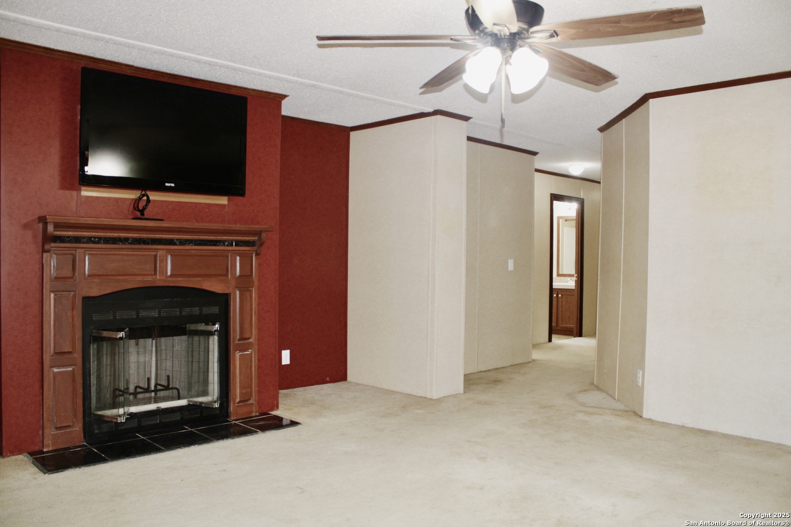 285 Rhonda Drive Lytle, TX 78052 - Photo 11 of 51 a living room with a fireplace and a flat screen tv