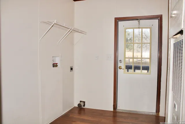 an empty room with chandelier fan and windows