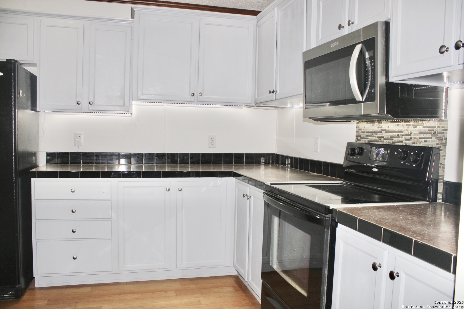 285 Rhonda Drive Lytle, TX 78052 - Photo 41 of 51 a kitchen with stainless steel appliances granite countertop a sink stove and microwave