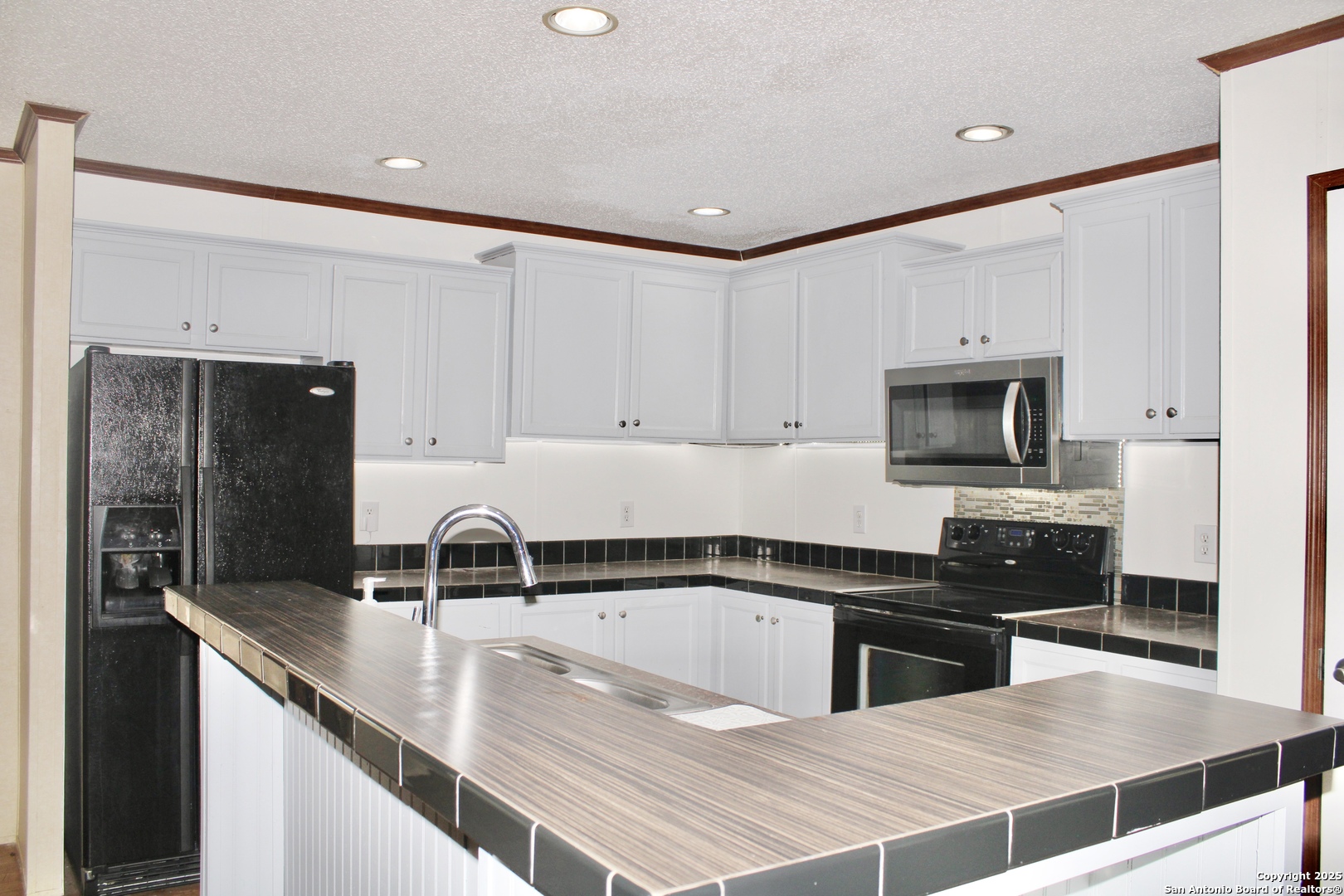 285 Rhonda Drive Lytle, TX 78052 - Photo 7 of 51 a kitchen with stainless steel appliances a sink a stove and microwave